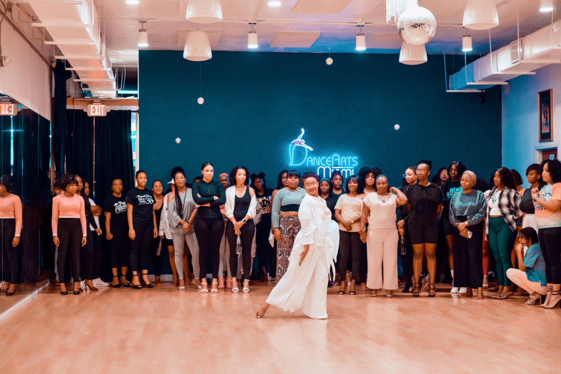 Sephora dancing in flowing white attire as workshop attendees watch from around the studio.